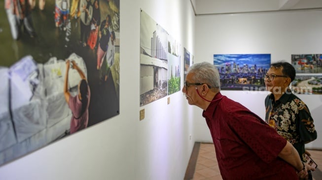 Pengunjung melihat foto yang dipamerkan pada pameran foto Rekam Jakarta 2025 di Cemara 6 Galeri, Jakarta, Sabtu (23/8/2025). [Suara.com/Alfian Winanto]