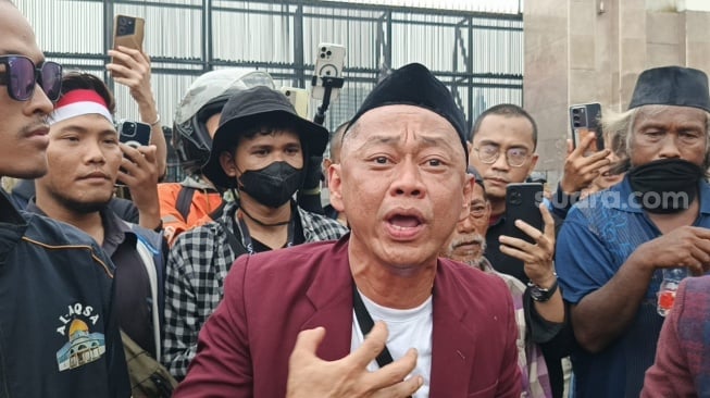 Bang Madun alias Nyak Kopsah di depan Gedung DPR, Senayan, Jakarta Pusat pada Senin, 25 Agustus 2025. [Suara.com/Rena Pangesti]