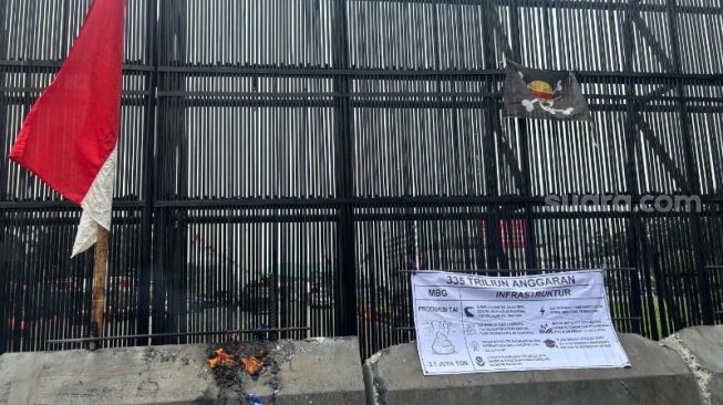 Meski Terhalang Beton Berlumur Oli, Massa Tetap Bisa Kibarkan Bendera One Piece di Gerbang DPR