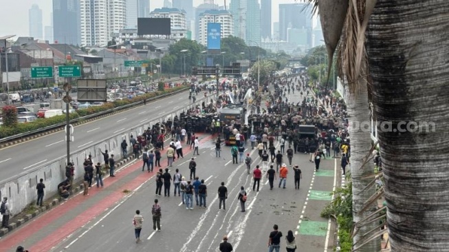 Ratusan massa aksi di depan Gedung DPR RI, Senayan, Jakarta, dipukul mundur oleh pihak kepolisian. (Suara.com/Faqih)