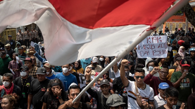Salah satu koordinator Aliansi Masyarakat Pati Bersatu, Supriyono alias Botok Pati mengibarkan bendera Merah Putih saat mengawal warga mengirimkan surat berisi desakan kepada Komisi Pemberantasan Korupsi (KPK) terkait dugaan korupsi Bupati Pati Sudewo melalui Kantor Pos Pati di Kabupaten Pati, Jawa Tengah Senin (25/8/2025). [ANTARA FOTO/Aji Styawan/rwa]