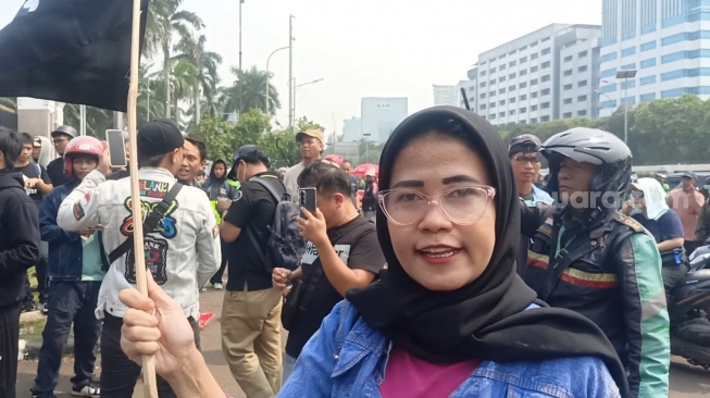 Perempuan bawa Bendera One Piece saat demo di depan Gedung DPR, Senayan, Jakarta Pusat pada Senin, 25 Agustus 2025. [Suara.com/Rena Pangesti]