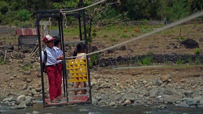 Dua siswa sekolah dasar menyeberangi Sungai Tompobulu menggunakan gondola ke Dusun Makmur, Desa Bonto Manurung, Kabupaten Maros, Sulawesi Selatan, Selasa (26/8/2025).  [ANTARA FOTO/Hasrul Said/nz]