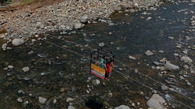 Foto udara anak-anak menyeberangi Sungai Tompobulu menggunakan gondola ke Dusun Makmur, Desa Bonto Manurung, Kabupaten Maros, Sulawesi Selatan, Selasa (26/8/2025).  [ANTARA FOTO/Hasrul Said/nz]