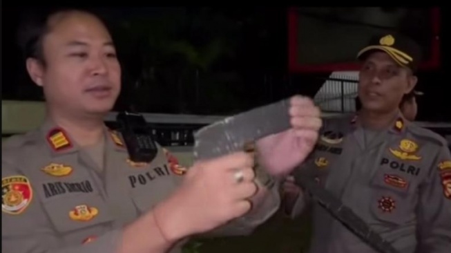 Polisi memeriksa parang replika yang terbuat dari kardus. Diamankan saat demo mahasiswa menolak kenaikan tunjangan Anggota DPR di Kota Makassar [SuaraSulsel.id/Istimewa]