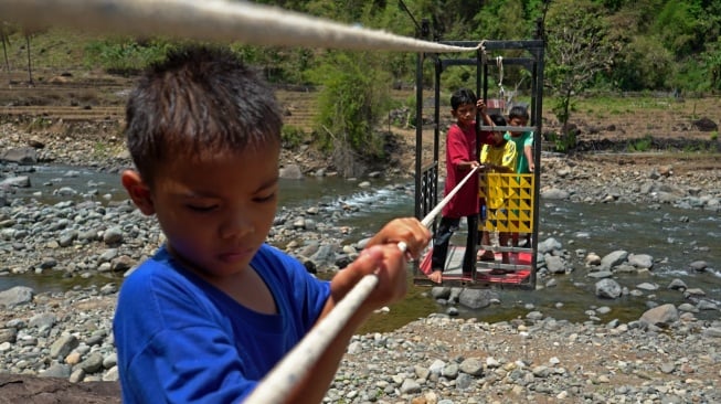 Sejumlah anak menyeberangi Sungai Tompobulu menggunakan gondola ke Dusun Makmur, Desa Bonto Manurung, Kabupaten Maros, Sulawesi Selatan, Selasa (26/8/2025).  [ANTARA FOTO/Hasrul Said/nz]