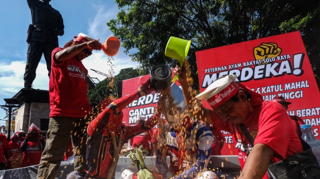 Anggota Peternak Ayam Rakyat Solo Raya melakukan mandi jagung saat aksi damai menyikapi harga jagung pakan ternak yang mahal di kawasan Gladak, Solo, Jawa Tengah, Selasa (26/8/2025). [ANTARAFOTO/Maulana Surya/YU]
