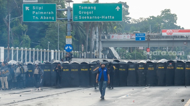 Personel polisi menghalau pengunjuk rasa saat menggelar aksi di depan Gedung DPR RI, Jakarta, Kamis (28/8/2025). [Suara.com/Alfian Winanto]
