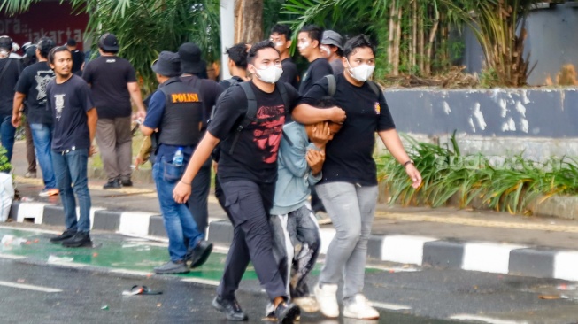 Personel polisi mengamankan pengunjuk rasa saat menggelar aksi di depan Gedung DPR RI, Jakarta, Kamis (28/8/2025). [Suara.com/Alfian Winanto]