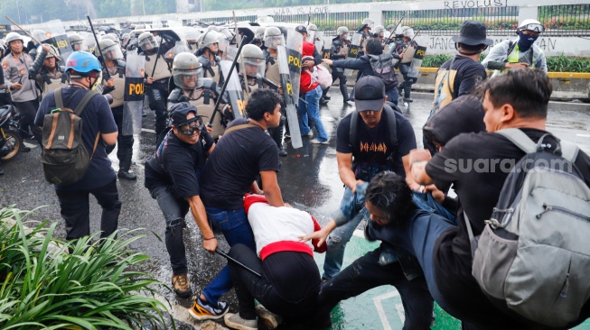 Personel polisi mengamankan pengunjuk rasa saat menggelar aksi di depan Gedung DPR RI, Jakarta, Kamis (28/8/2025). [Suara.com/Alfian Winanto]