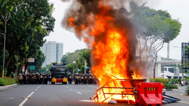 Massa aksi bentrok dengan personel kepolisian di kawasan Senayan saat menggelar unjuk rasa di depan Gedung DPR RI, Jakarta, Kamis (28/8/2025). [Suara.com/Alfian Winanto]