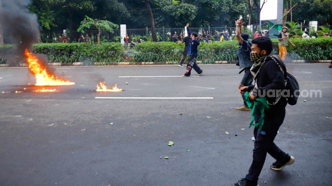 Massa aksi bentrok dengan personel kepolisian di kawasan Senayan saat menggelar unjuk rasa di depan Gedung DPR RI, Jakarta, Kamis (28/8/2025). [Suara.com/Alfian Winanto]