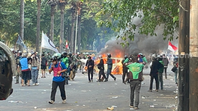 Situasi di depan Markas Komando (Mako) Brimob Kwitang, Jakarta Pusat, Jumat (29/8/2025) sore masih memanas. Massa bakar mobil. (Suara.com/Yaumal)