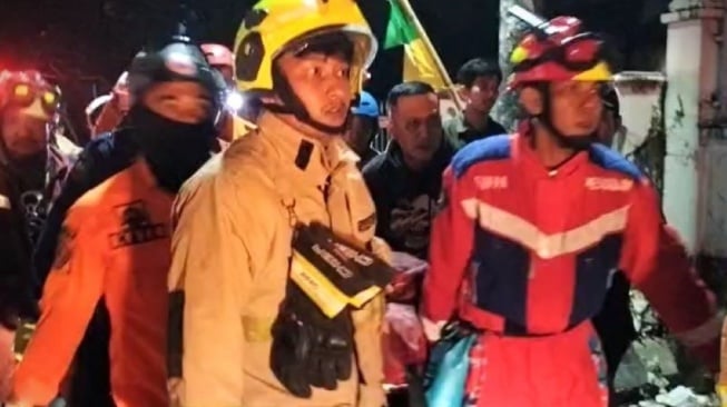 Tim penyelamat mengevakuasi korban yang terjebak kebakaran saat kejadian pembakaran Kantor DPRD Kota Makassar, Sulawesi Selatan, Sabtu (30/8/2025) dini hari.   [Antara/Darwin Fatir]