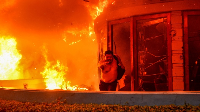 Seorang pegawai Mess MPR RI berlari keluar ruangan yang terbakar di Bandung, Jawa Barat, Jumat (29/8/2025). [ANTARA FOTO/Raisan Al Farisi/rwa]
