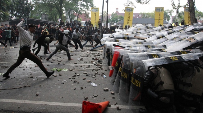 Pengunjuk rasa melempar batu ke barikade polisi saat aksi di depan Gedung DPRD Sumatera Utara, Medan, Jumat (29/8/2025). [ANTARA FOTO/Yudi Manar/rwa]