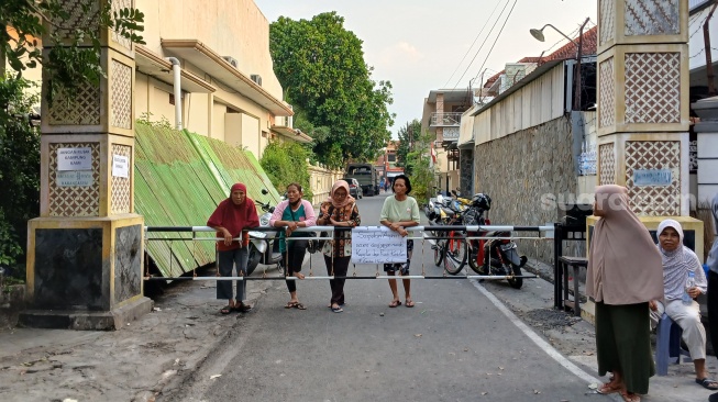 Warga sedang berjaga di jalan kampung saat ada aksi unjuk rasa, Senin (1/9/2025). [Suara.com/Ari Welianto]