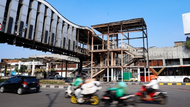 Kendaraan melintas di depan Halte Transjakarta Pasar Senen pasca terbakar di Jakarta, Senin (1/9/2025). [Suara.com/Alfian Winanto]