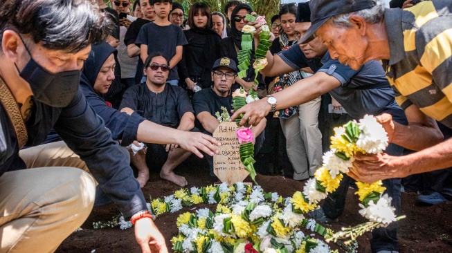 Keluarga menaburkan bunga saat pemakaman jenazah personel grup musik Bimbo, Raden Darmawan Dajat Hardjakusumah atau Acil Bimbo di TPU Cipageran, Kota Cimahi, Jawa Barat, Selasa (2/9/2025). [ANTARA FOTO/Abdan Syakura/bar]