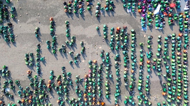 Foto udara ratusan pengemudi ojek online mengikuti doa bersama di parkir timur GOR Delta Sidoarjo, Jawa Timur, Jumat (5/9/2025). [ANTARA FOTO/Umarul Faruq/YU]