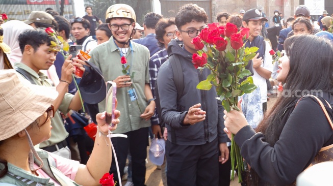 Influencer Gusti Ayu Dewanti membagikan bunga saat mengikuti aksi piknik di depan Gedung DPR RI, Jakarta, Jumat (5/9/2025). [Suara.com/Alfian Winanto]
