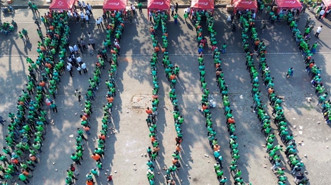 Foto udara ratusan pengemudi ojek online antre untuk menerima bantuan beras seusai doa bersama di parkir timur GOR Delta Sidoarjo, Jawa Timur, Jumat (5/9/2025). [ANTARA FOTO/Umarul Faruq/YU]
