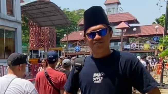 Urfan, penonton dari Lumajang mengenakan peci dan sarung di gelaran Pestapora hari pertama di JIExpo Kemayoran, Jakarta Pusat pada Jumat, 5 September 2025. [Suara.com/Tiara Rosana]