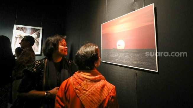 Sejumlah pengunjung mengamati karya foto dalam pameran 80 Tahun Keberagaman Republik Indonesia: Potret Bangsa dalam Lensa di Museum Nasional, Jakarta, Sabtu (6/9/2025). [Suara.com/Alfian Winanto]