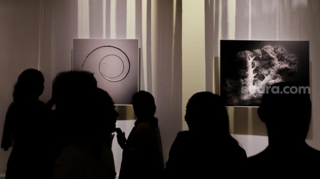 Sejumlah pengunjung mengamati karya foto dalam pameran 80 Tahun Keberagaman Republik Indonesia: Potret Bangsa dalam Lensa di Museum Nasional, Jakarta, Sabtu (6/9/2025). [Suara.com/Alfian Winanto]