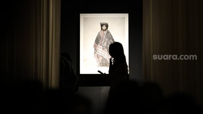 Sejumlah pengunjung mengamati karya foto dalam pameran 80 Tahun Keberagaman Republik Indonesia: Potret Bangsa dalam Lensa di Museum Nasional, Jakarta, Sabtu (6/9/2025). [Suara.com/Alfian Winanto]