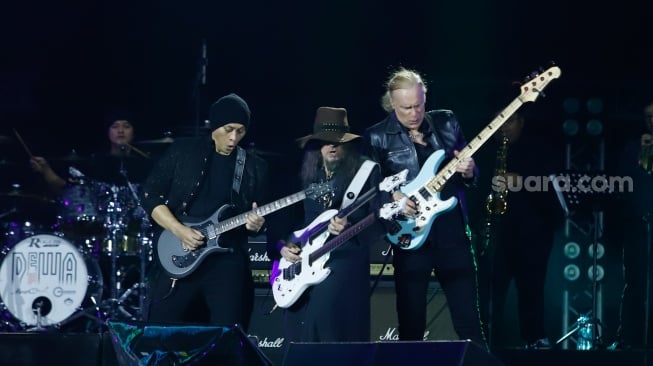 Gitaris Dewa 19 Andra (kiri) bersama Musisi Internasional Ron 'Bumblefoot' Thal (tengah) dan Billy Sheehan tampil menghibur penonton pada Konser Dewa19 featuring All Stars 2.0 di Stadion Utama Gelora Bung Karno (SUGBK), Jakarta, Sabtu (6/9/2025). [Suara.com/Alfian Winanto]