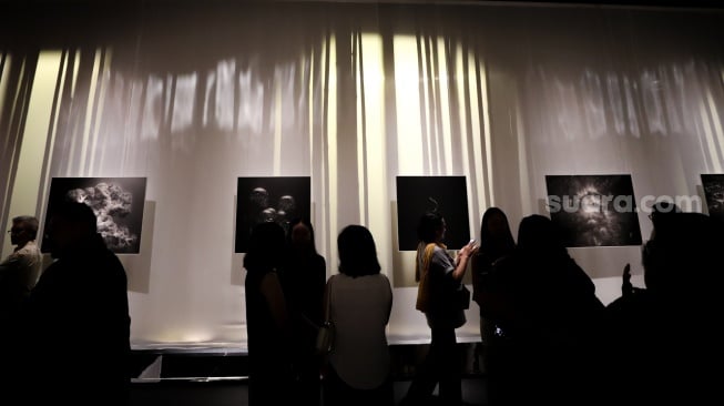 Sejumlah pengunjung mengamati karya foto dalam pameran 80 Tahun Keberagaman Republik Indonesia: Potret Bangsa dalam Lensa di Museum Nasional, Jakarta, Sabtu (6/9/2025). [Suara.com/Alfian Winanto]