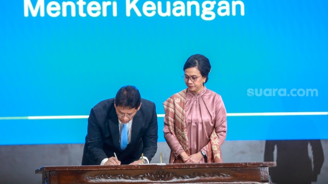 Menteri Keuangan Purbaya Yudhi Sadewa (kiri) menandatangani memori jabatan dari pejabat lama Sri Mulyani Indrawati saat serah terima jabatan di Kementerian Keuangan, Jakarta, Selasa (9/9/2025). [Suara.com/Alfian Winanto]