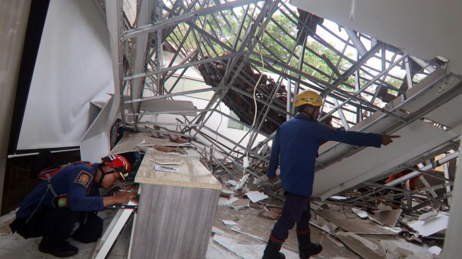 Petugas Damkar Kabupaten Bogor menyelamatkan barang siswa yang teringgal di reruntuhan atap bangunan SMKN 1 Cileungsi, Kabupaten Bogor, Jawa Barat, Rabu (10/9/2025).  [ANTARA FOTO/Yulius Satria Wijaya/nym]