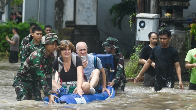 Petugas mengevakuasi wisatawan mancanegara yang terjebak banjir di kawasan Kuta, Badung, Bali, Rabu (10/9/2025). [ANTARA FOTO/Fikri Yusuf/nym]