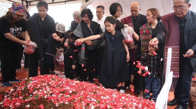 Istri almarhum Zetro Leonardo Purba Priskila Serapinta (kedua kiri) beserta keluarga menaburkan bunga ke makam suaminya usai dimakamkan di TPU Sari Mulya, Setu, Tangerang Selatan, Banten, Kamis (11/9/2025).  [ANTARA FOTO/Muhammad Iqbal/bar]

