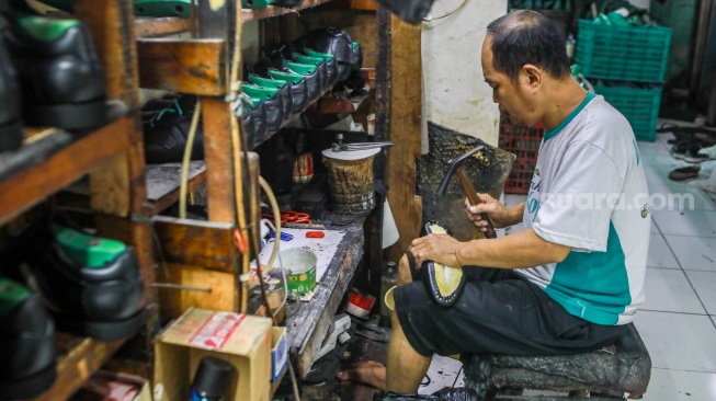 Pekerja menyelesaikan pembuatan sepatu Flavio Boston di Cakung, Jakarta, Kamis (11/9/2025). [Suara.com/Alfian Winanto]