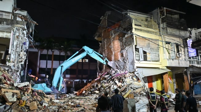 Petugas menggunakan alat berat melakukan proses pencarian korban di sekitar bangunan ruko yang hancur akibat diterjang banjir di kawasan Jalan Sulawesi, Denpasar, Bali, Kamis (11/9/2025). [ANTARA FOTO/Fikri Yusuf/YU]