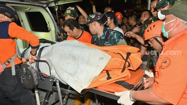 Petugas memindahkan kantong jenazah korban yang ditemukan di sekitar bangunan ruko yang hancur akibat diterjang banjir di kawasan Jalan Sulawesi, Denpasar, Bali, Kamis (11/9/2025). [ANTARA FOTO/Fikri Yusuf/YU]