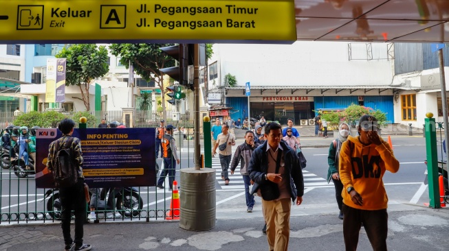 Pejalan kaki menyeberang pada pelican crossing di depan Stasiun Cikini, Jakarta, Senin (15/9/2025). [Suara.com/Alfian Winanto]