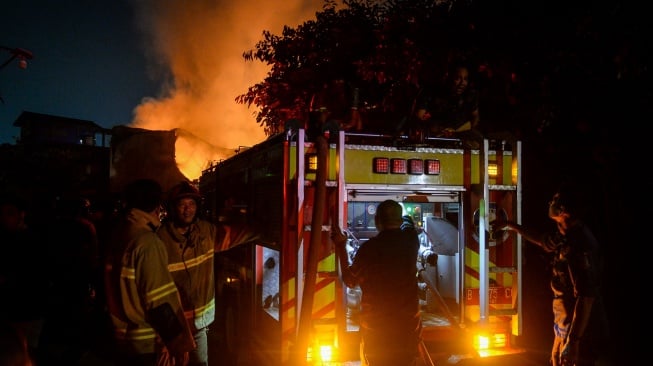 Petugas Damkar mengalirkan air dari mobil pemadam saat kebakaran pabrik konstruksi di Serpong Utara, Kota Tangerang Selatan, Banten, Senin (15/9/2025). [ANTARA FOTO/Putra M. Akbar/nz]