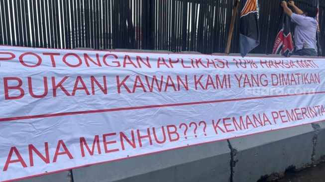 Massa Ojol Bentangkan Spanduk di DPR: Potongan 10 Persen Harga Mati, Bukan Kawan Kami yang Dimatikan