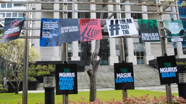 Peserta aksi yang tergabung dalam Koalisi Masyarakat Sipil Untuk Reformasi Sektor Keamanan mengangkat poster saat mengikuti aksi di depan Gedung Mahkamah Konstitusi (MK), Jakarta, Rabu (17/9/2025). [Suara.com/Alfian Winanto]