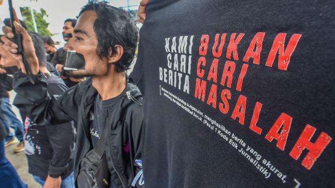 Sejumlah jurnalis dan pers mahasiswa yang tergabung dalam Koalisi Anti Pembungkaman Demokrasi melakukan aksi diam sambil membentangkan poster di Mapolda Jambi, Jambi, Rabu (17/9/2025). [ANTARA FOTO/Wahdi Septiawan/bar]