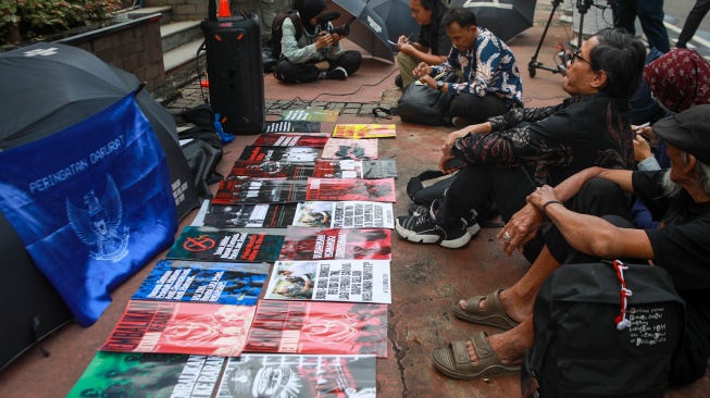 Peserta aksi yang tergabung dalam Koalisi Masyarakat Sipil Untuk Reformasi Sektor Keamanan mengangkat poster saat mengikuti aksi di depan Gedung Mahkamah Konstitusi (MK), Jakarta, Rabu (17/9/2025). [Suara.com/Alfian Winanto]
