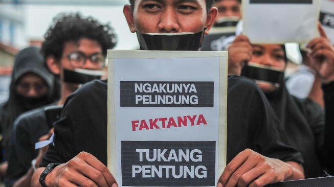 Sejumlah jurnalis dan pers mahasiswa yang tergabung dalam Koalisi Anti Pembungkaman Demokrasi melakukan aksi diam sambil membentangkan poster di Mapolda Jambi, Jambi, Rabu (17/9/2025). [ANTARA FOTO/Wahdi Septiawan/bar]