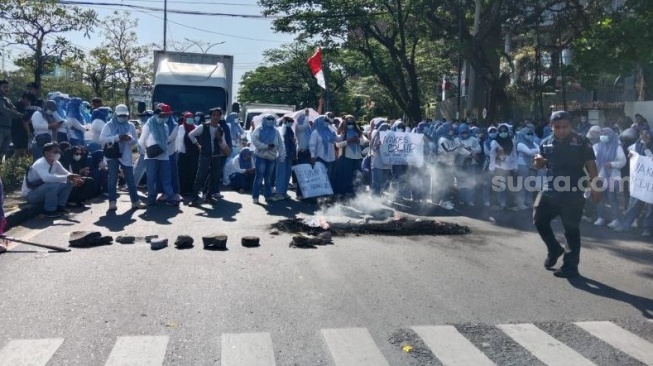 Puluhan tenaga kesehatan perempuan di Sulawesi Selatan berunjuk rasa di depan kantor Gubernur Sulsel. Mereka menuntut upah layak hingga menolak praktik nepotisme [SuaraSulsel.id/Lorensia Clara]