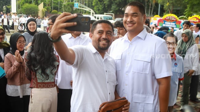 Pejabat lama Menteri Pemuda dan Olahraga Dito Ariotedjo berswafoto dengan pegawai Kemenpora saat acara perpisahan di Kantor Kemenpora, Jakarta, Kamis (18/9/2025). [Suara.com/Alfian Winanto]