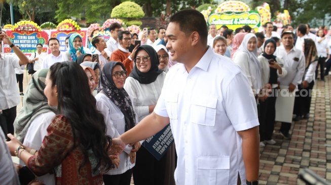 Pejabat lama Menteri Pemuda dan Olahraga Dito Ariotedjo dan istrinya Niena Kirana berjabat tangan dengan pegawai Kemenpora saat acara perpisahan di Kantor Kemenpora, Jakarta, Kamis (18/9/2025). [Suara.com/Alfian Winanto]