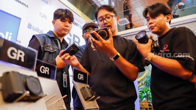 Pengunjung mencoba kamera Ricoh GR IV terbaru di Jakarta, Kamis, (18/9/2025). [Suara.com/Alfian Winanto]